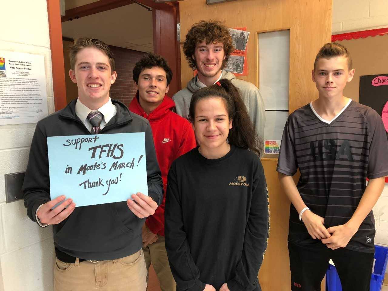 5 students who are planning to participate in the march, one holding a sign asking for support